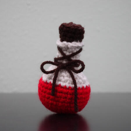 a crochet red potion bottle